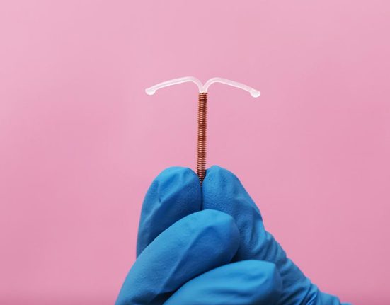 iud contraceptive method Doctor holding T-shaped intrauterine birth control device